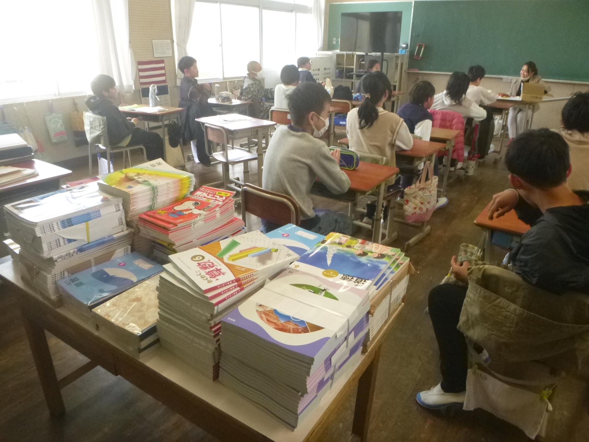 新しい教科書を背に先生のお話を聞く