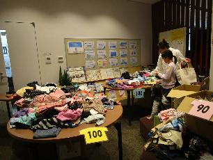 リユースコーナーで子ども服を選ぶ親子