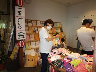 リユースコーナーで子ども服を選ぶ女性