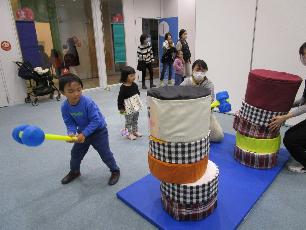 大きなだるま落としをする男の子