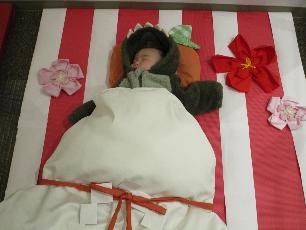 鏡餅の衣装を着て寝ころぶ赤ちゃん