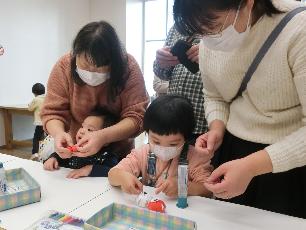 だるまの工作をする親子