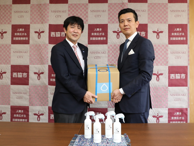 次亜塩素酸水溶液を片山市長に手渡す小澤社長