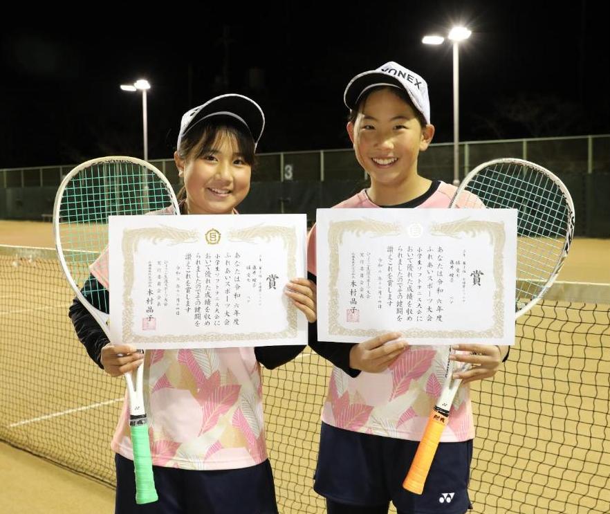 表彰状とラケットを持つ2人