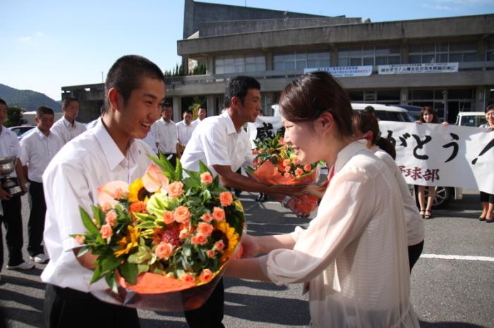 市職員から花束を受け取る木谷監督と山中主将