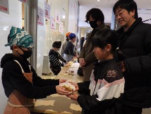 作ったカレーを手渡す小学生キッチンスタッフ