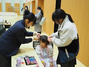 高校生手作りの衣装を着てヘアメイクをしてもらう子ども
