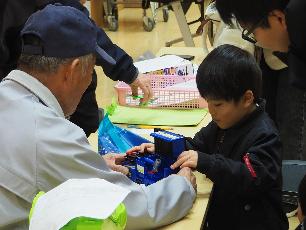 おもちゃドクターにおもちゃを診てもらう子ども