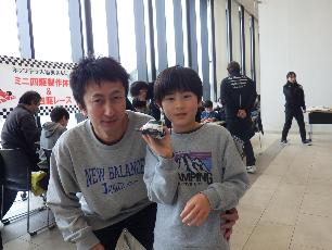 完成したミニ四駆を持っている小学生と父