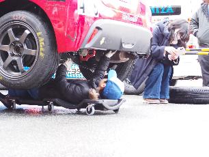 車の下にもぐってタイヤ交換する子ども