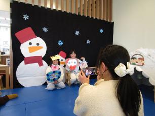 雪だるまのフォトスポットで記念撮影する子ども