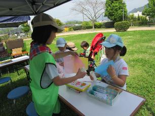 工作の材料を参加者に渡すキッズ・ジュニアサポーターの小学生