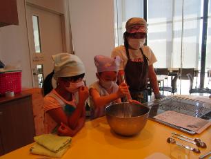 シフォンケーキの生地を混ぜる小学生