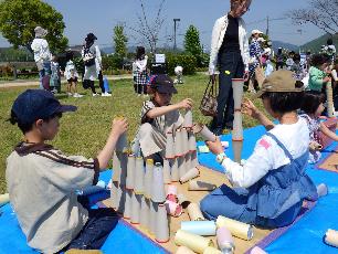 播州織の紙管を積んで遊ぶ小学生