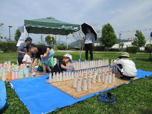 空き缶や紙管を積んで遊ぶ子ども