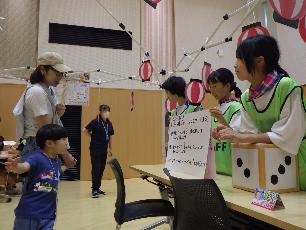 大型すごろくの説明をするキッズ・ジュニアサポーターの小学生