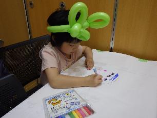バルーンのはちまきをつけてうちわ作りをする子ども