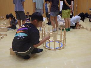 ひのきの積み木を積んでいる小学生