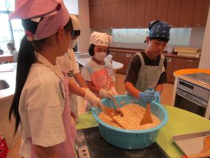 砂糖を絡めてポン菓子を作る小学生