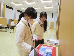 手提げ袋のパッチワーク部分を作る小学生